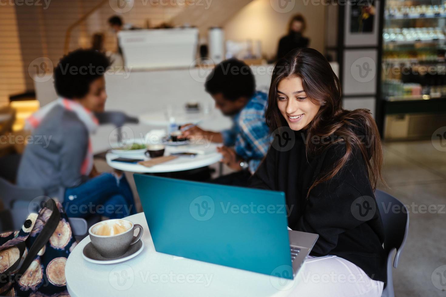 portrait d'une étudiante utilisant un net-book assis dans un café photo