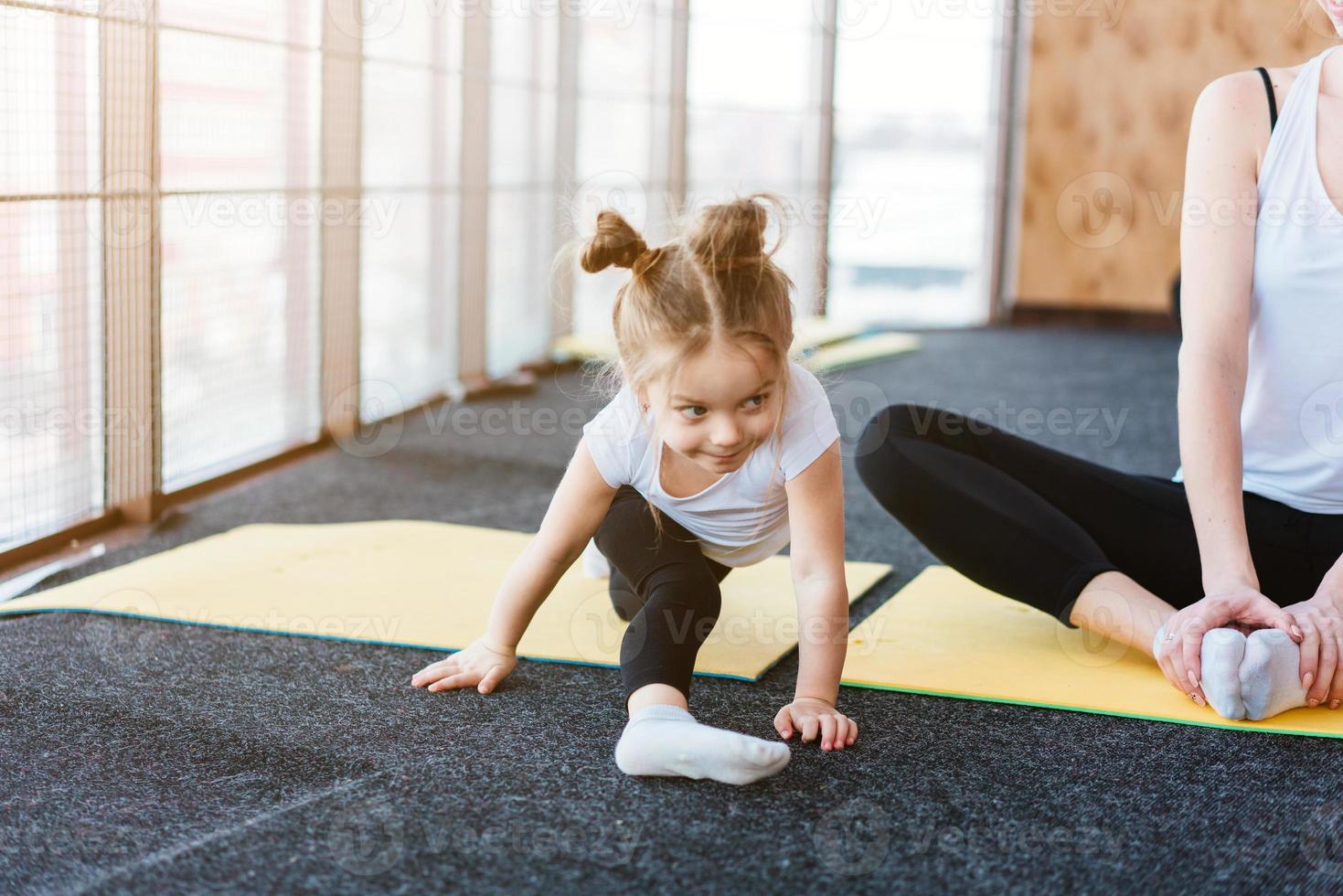 une petite fille répète des exercices pour sa mère photo