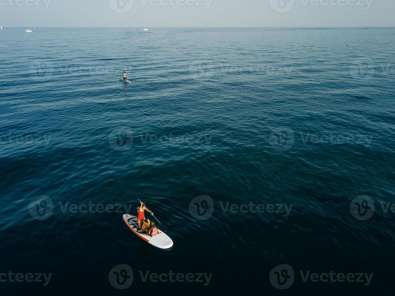 mère avec deux filles debout sur un paddle board photo