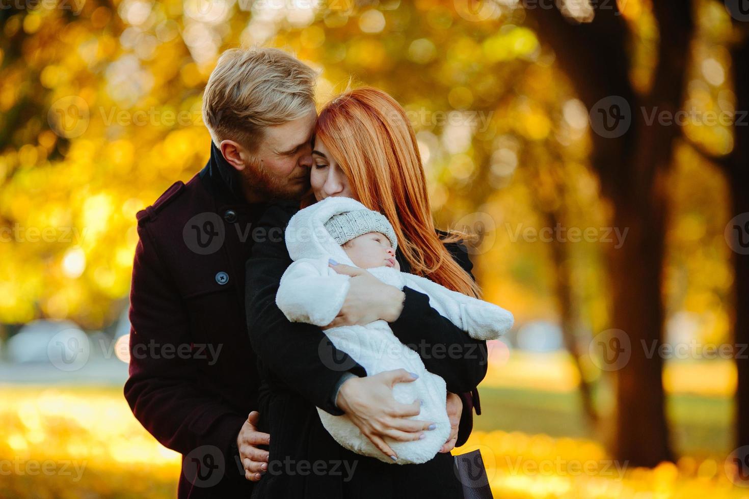 jeune famille et fils nouveau-né dans le parc d'automne photo