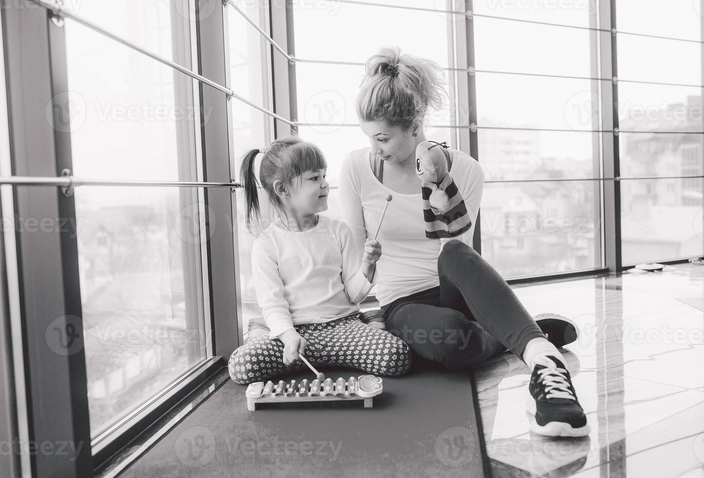 mère et fille jouant avec des jouets dans la salle de gym photo