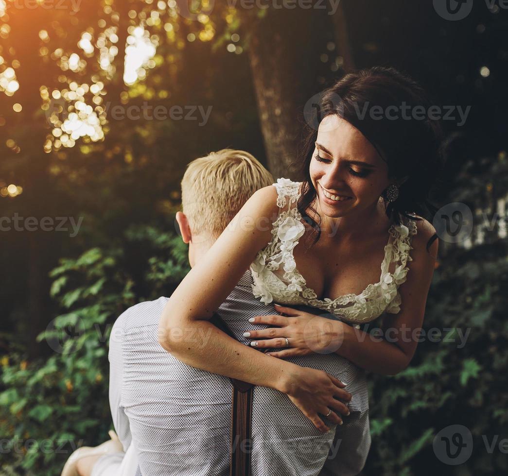 marié tient la mariée dans ses bras photo