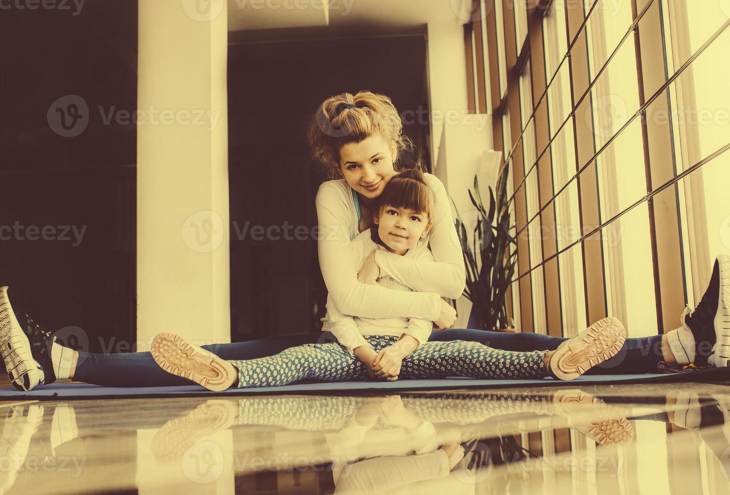 mère et fille s'embrassent et s'étirent dans la salle de sport photo