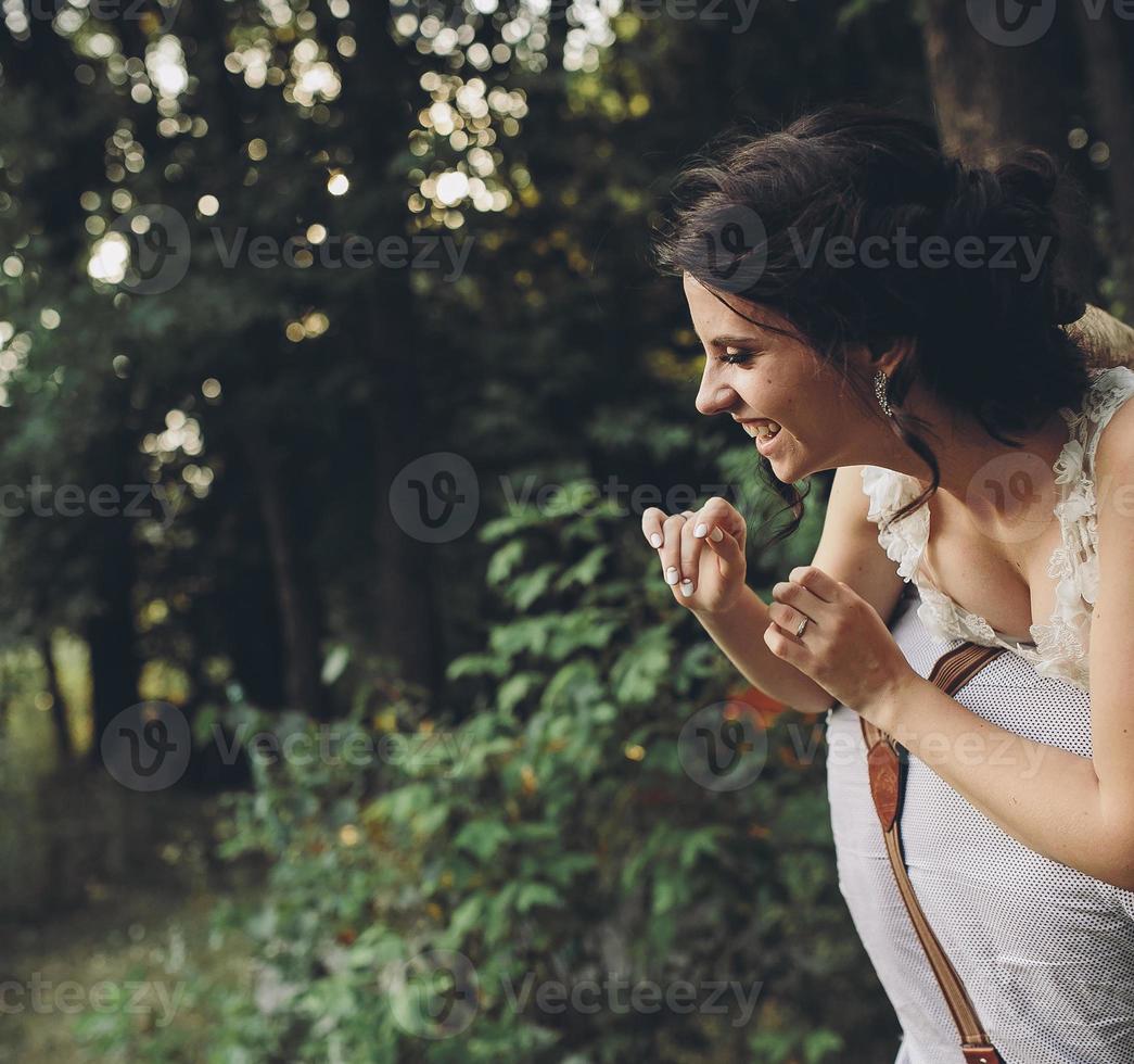 marié tient la mariée dans ses bras photo