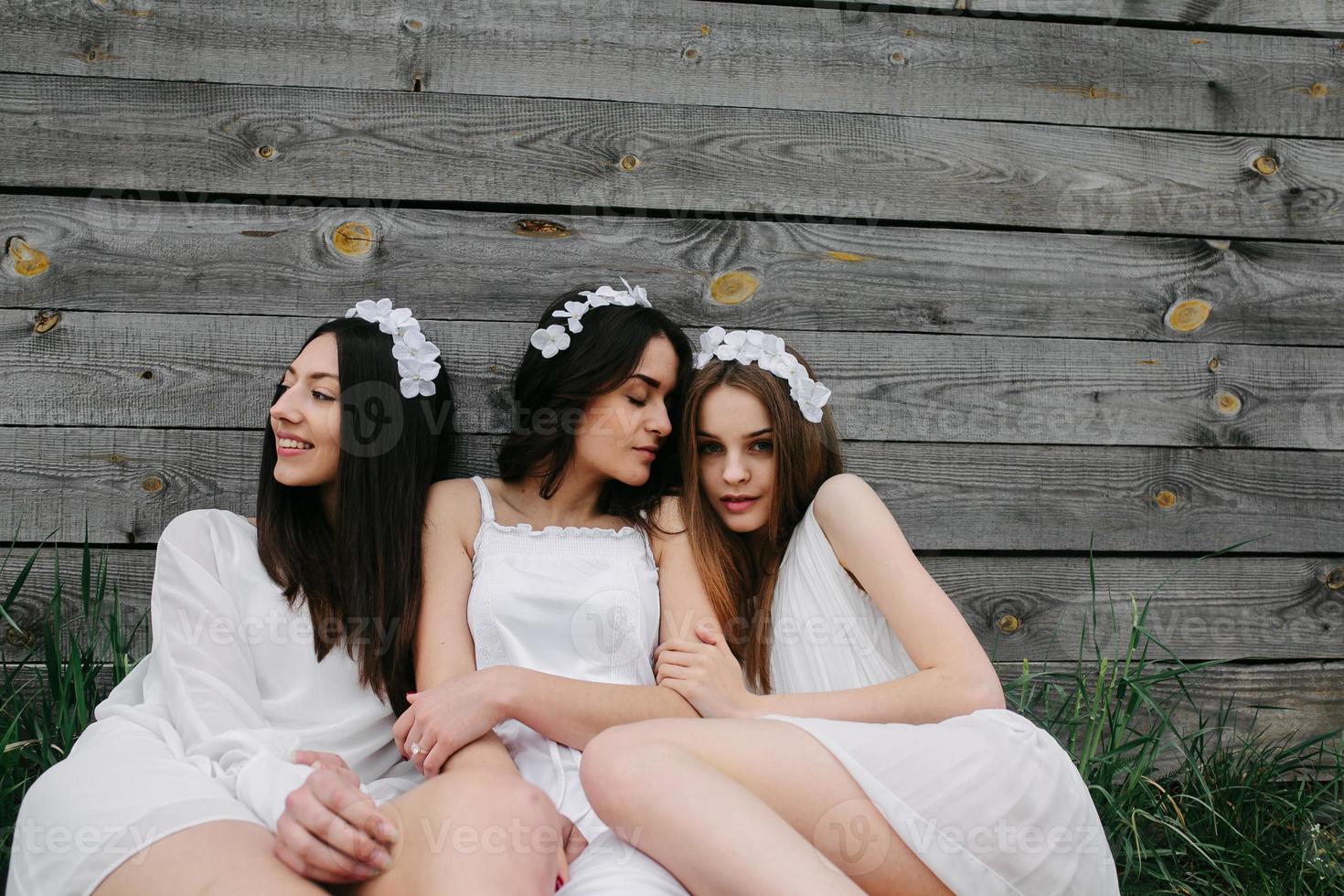 trois charmantes filles près d'une maison en bois photo