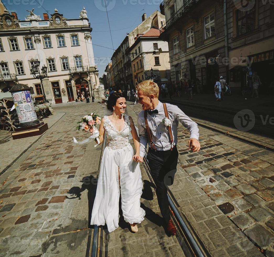 la mariée et le marié courant dans les rues photo