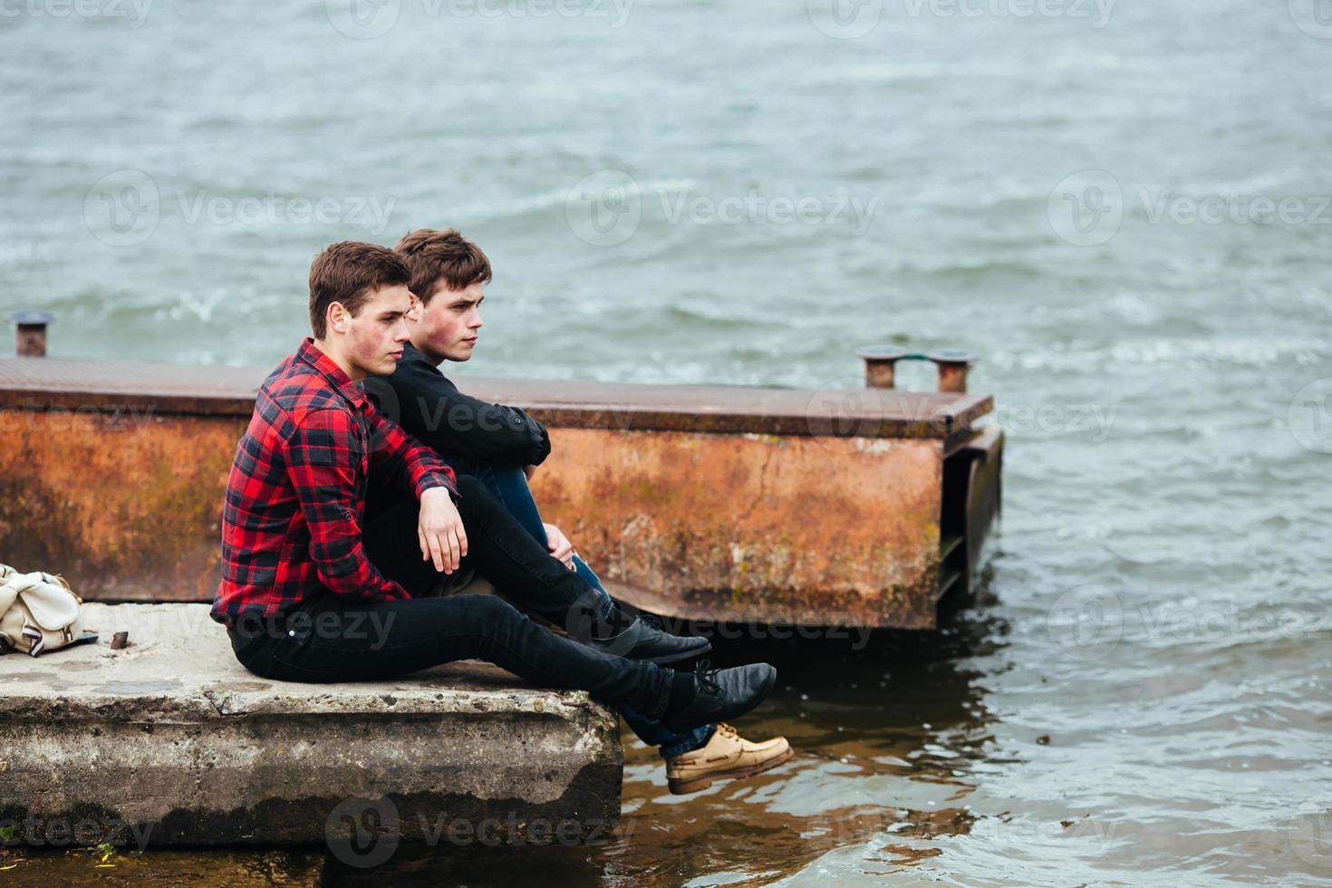 deux amis se détendre sur la jetée. photo