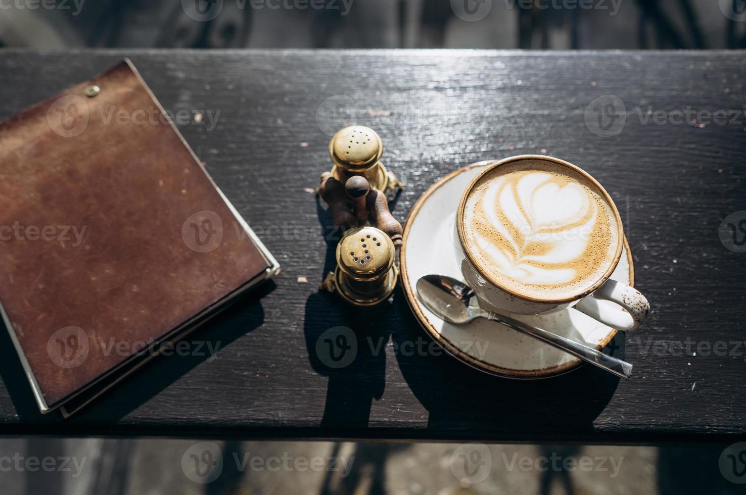 café café dans une tasse blanche avec un motif de feuilles photo