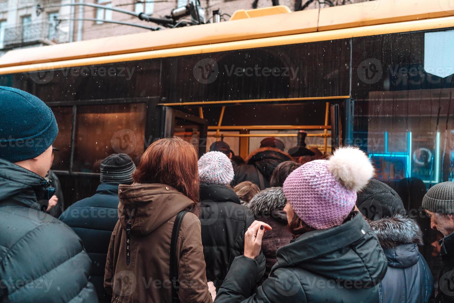 de nombreuses personnes non identifiées attendent le transport urbain à l'arrêt de bus photo