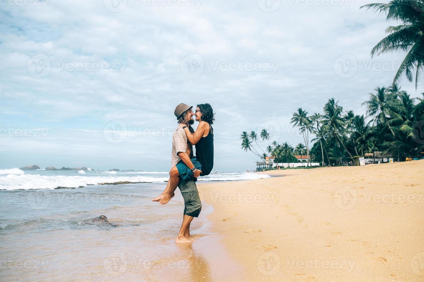 un mec et une fille s'embrassent sur la plage photo
