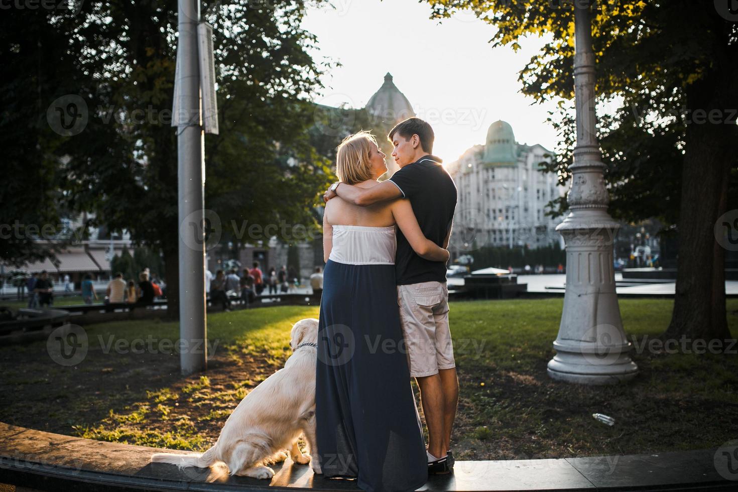 garçon et fille regardant le coucher du soleil avec un chien photo