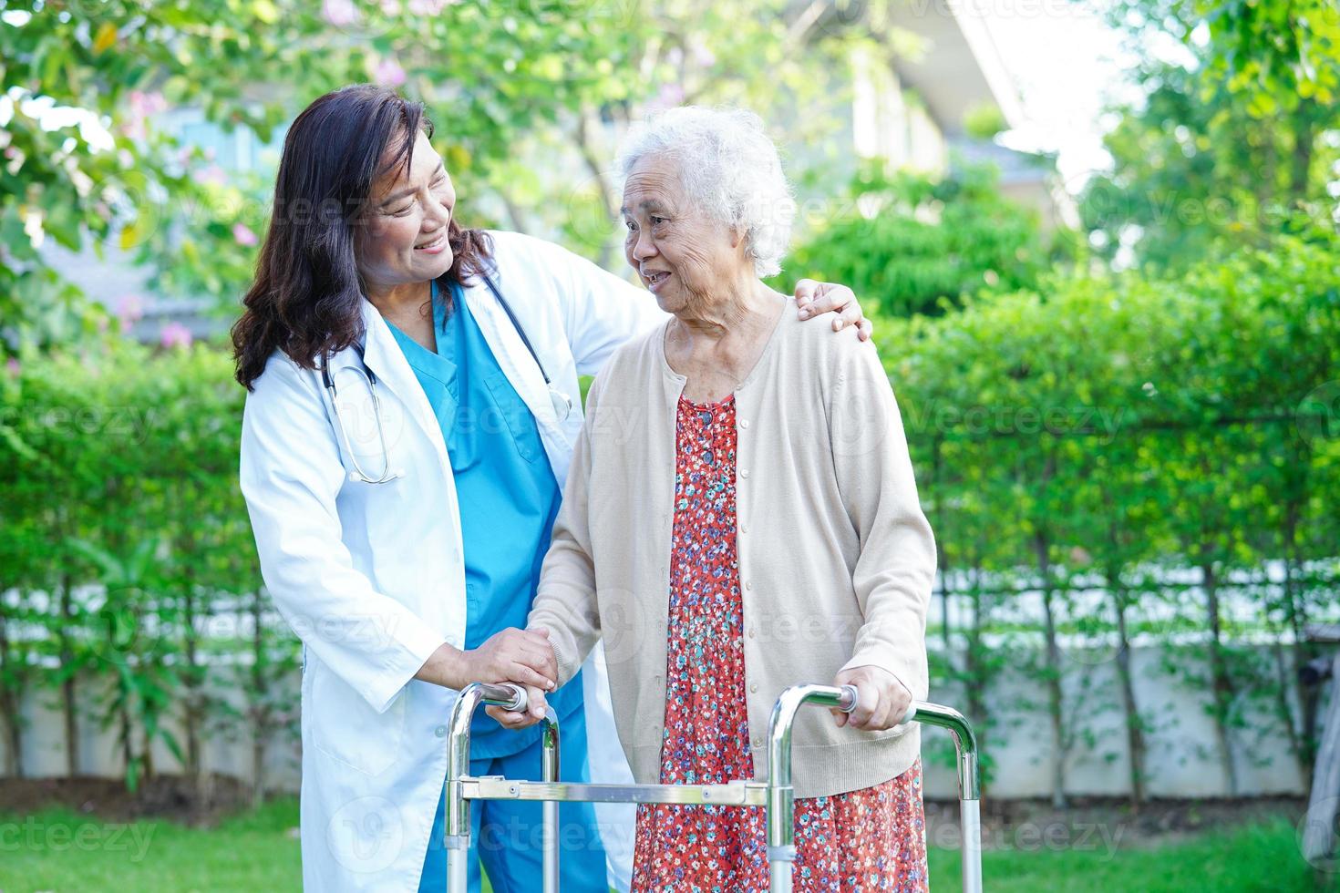 médecin aide une femme âgée asiatique handicapée à marcher avec une marchette dans le parc, concept médical. photo