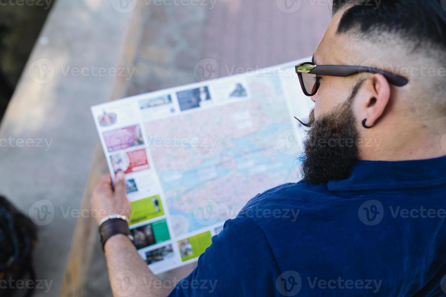 homme barbu regardant une carte photo