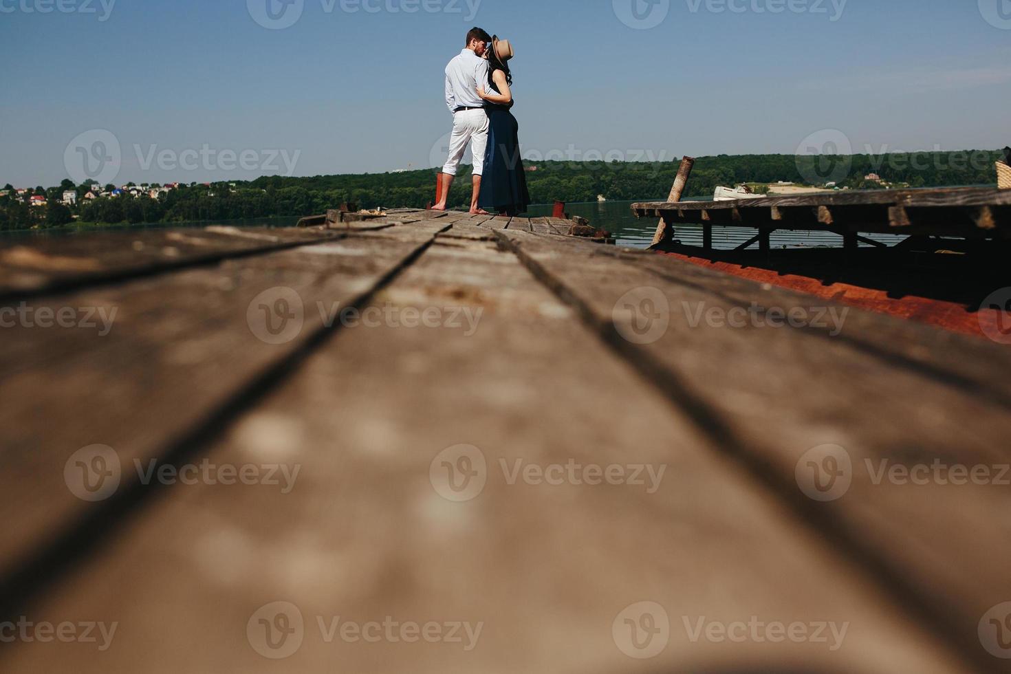 étreindre homme et femme amoureux sur une jetée en bois photo