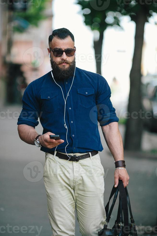 homme barbu va et écoute de la musique photo