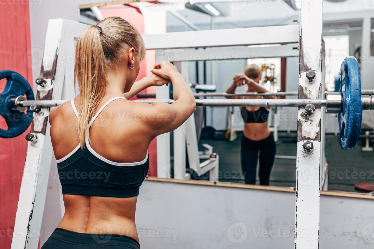 Fitness femme préparant des haltères squats dans une salle de sport photo