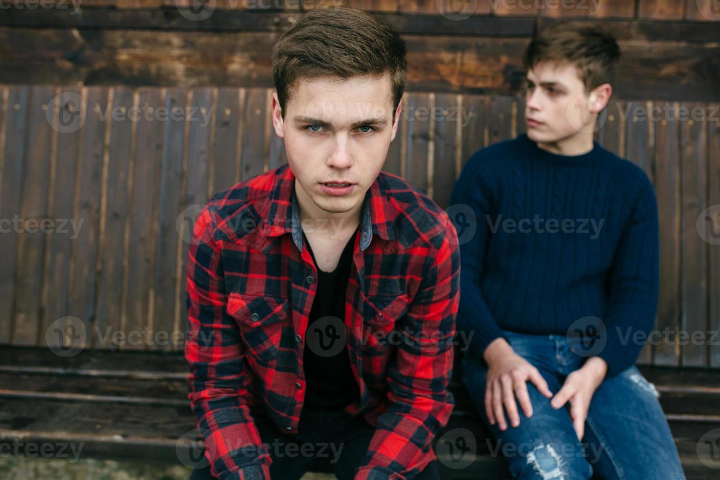 deux hommes assis sur un banc en bois photo