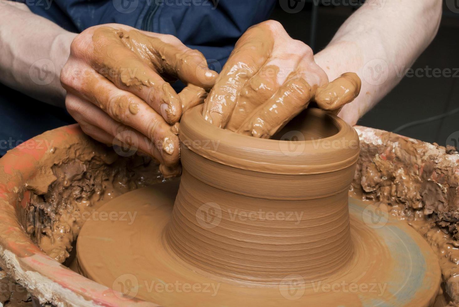 mains d'un potier, créant un pot en terre photo