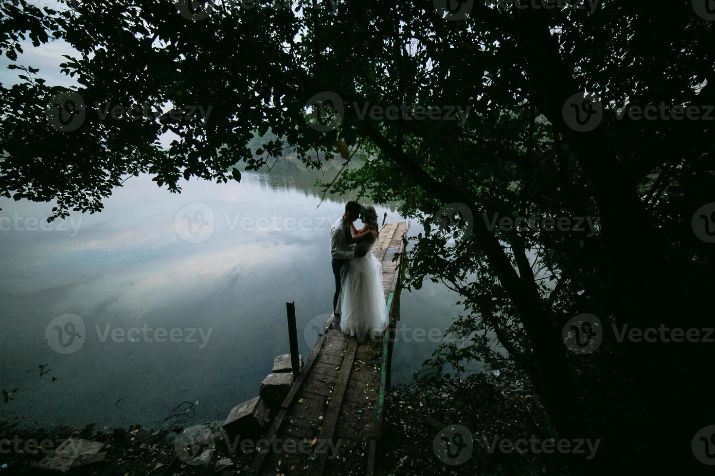 couple de mariage sur la vieille jetée en bois photo