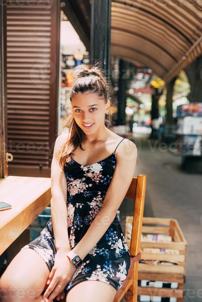 séduisante jeune femme caucasienne assise dans un café de rue photo