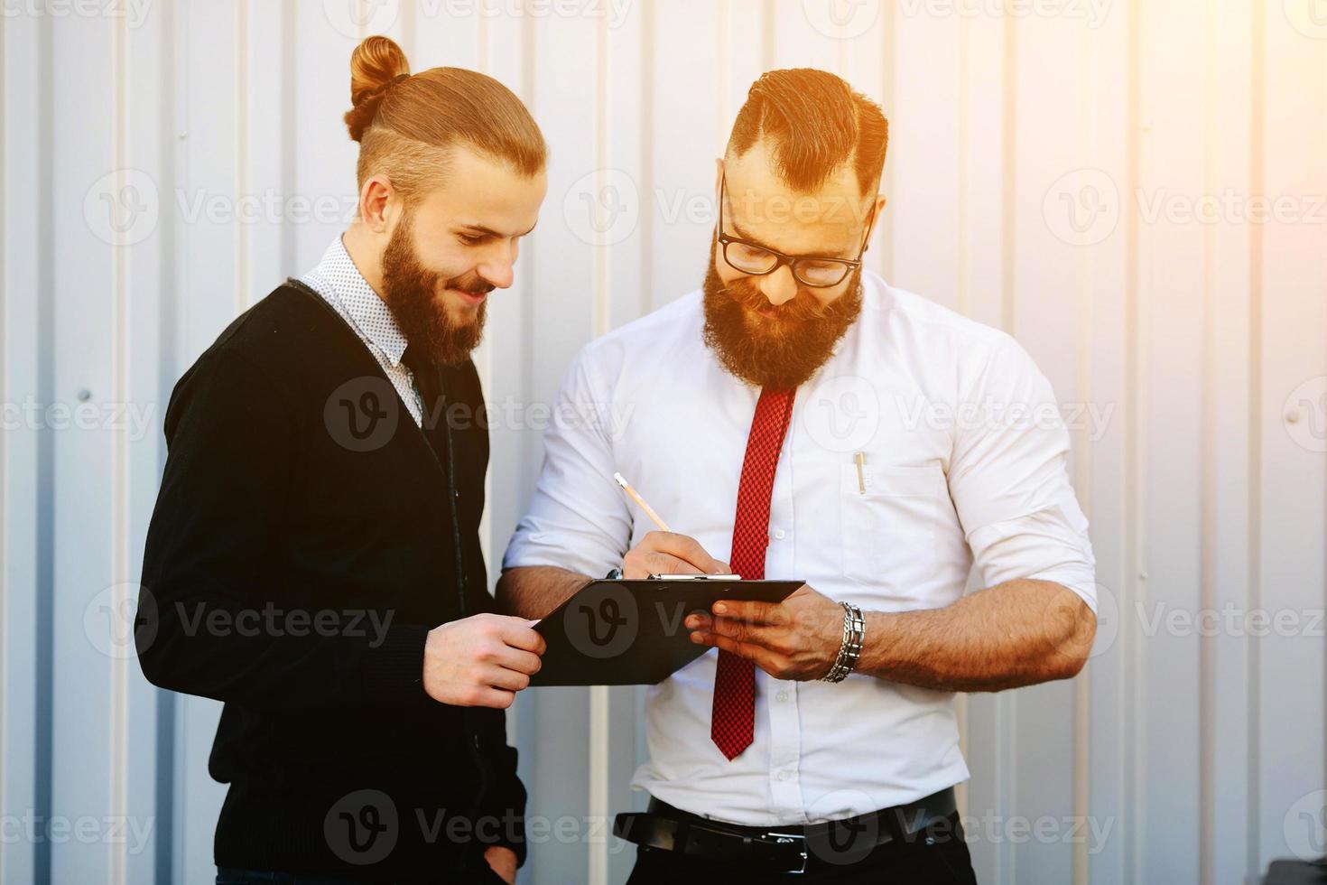 deux hommes d'affaires barbus signant des documents photo