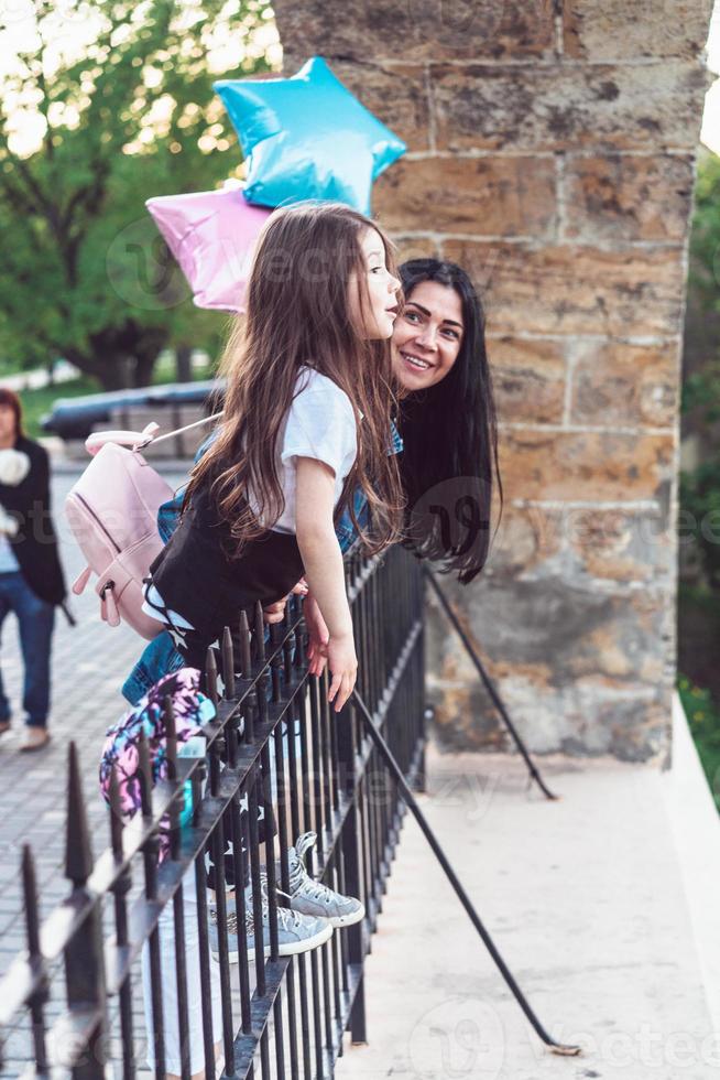 fille d'âge préscolaire et mère à la clôture photo