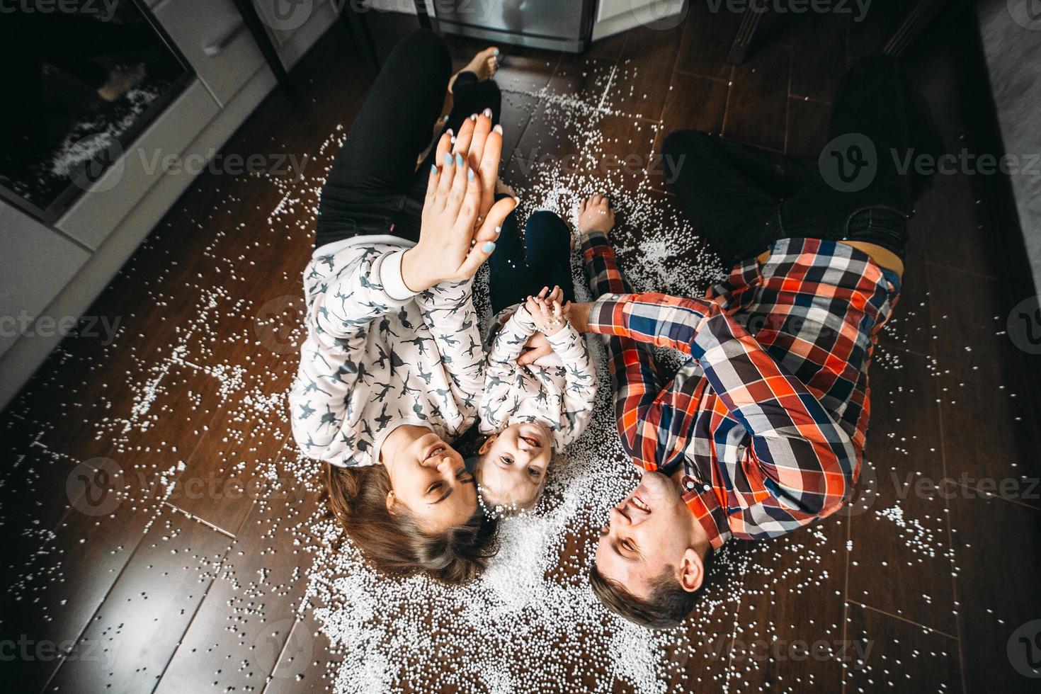 famille heureuse jouant ensemble sur le sol photo