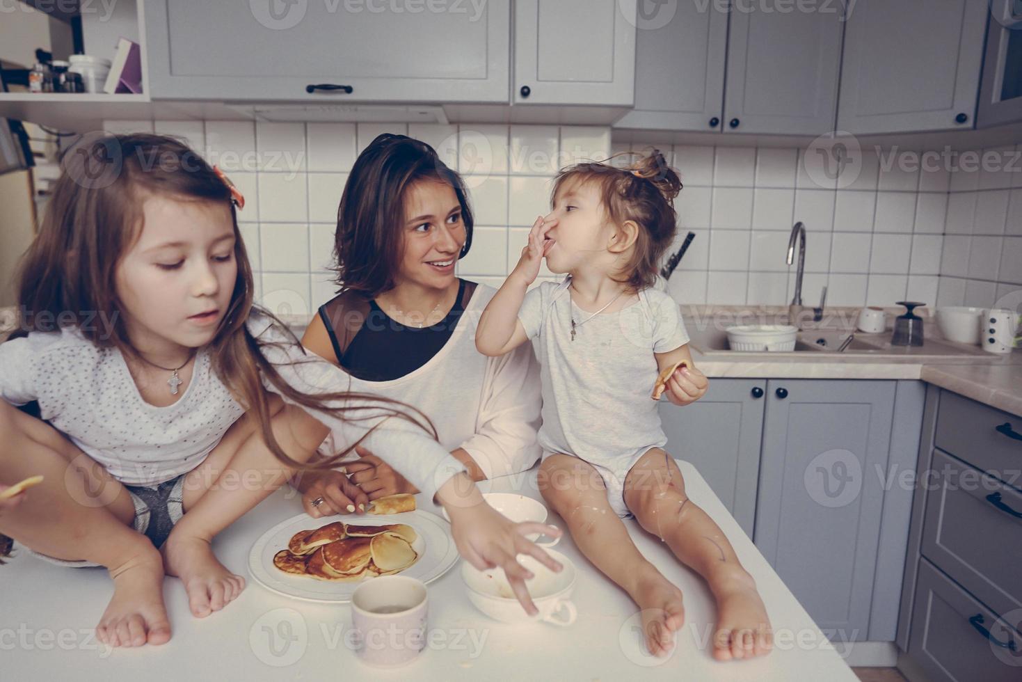 maman et ses deux filles mangent des crêpes photo