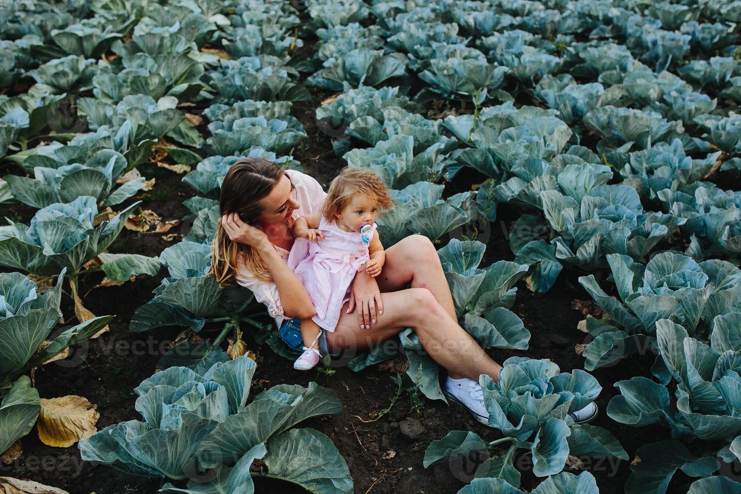 mère et fille sur le terrain avec du chou photo