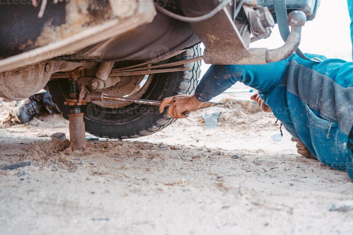 un homme soulève sur un cric 4x4 camion hors route photo