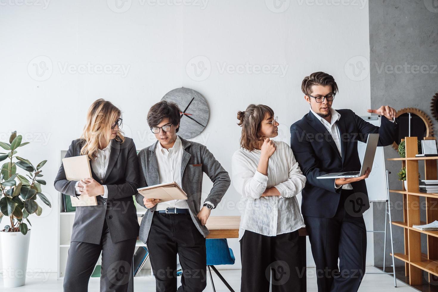 les gens d'affaires debout dans le bureau discutent photo