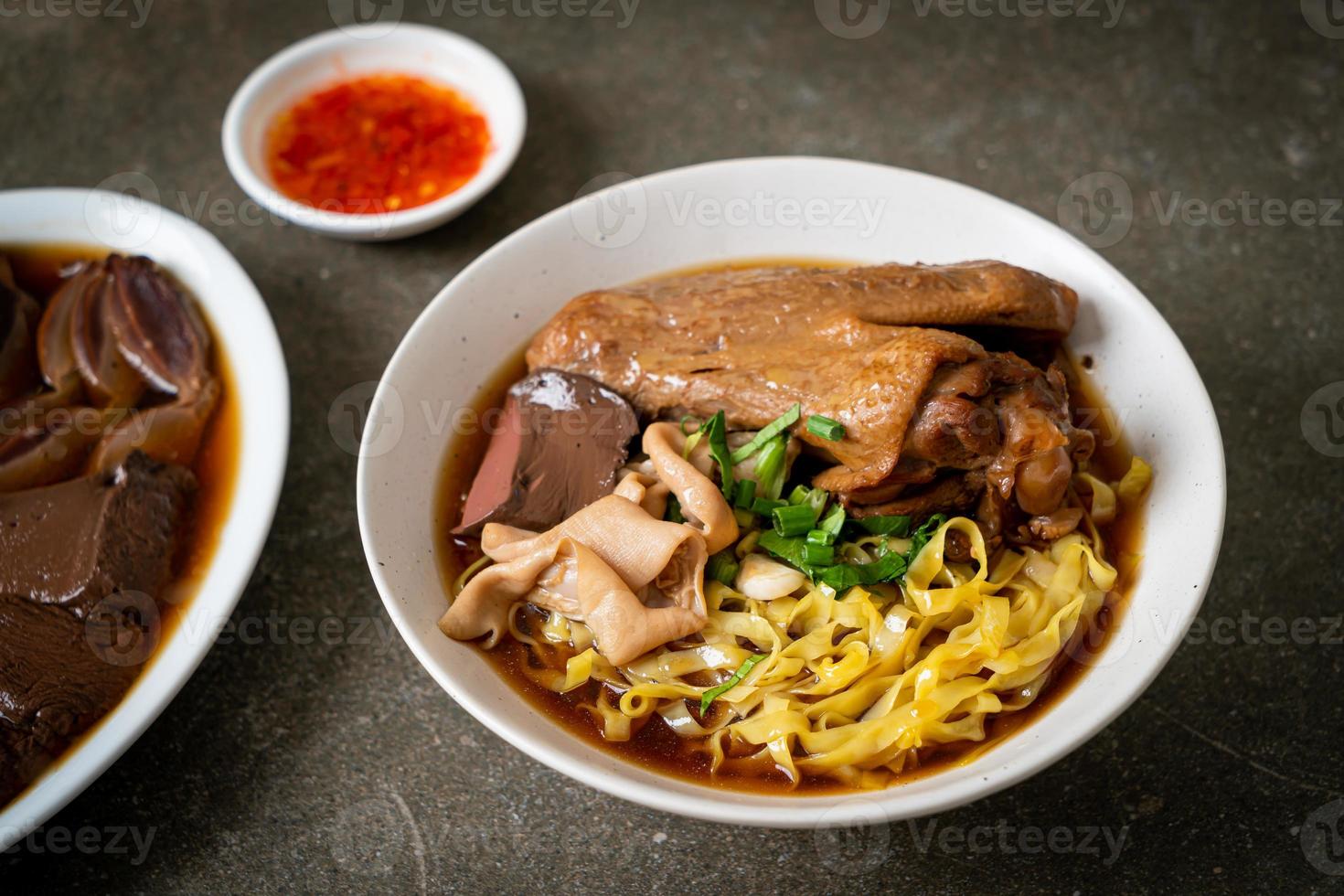 nouilles aux œufs avec canard mijoté et braisé dans une soupe brune photo