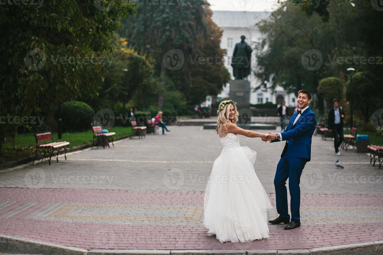 le marié tient la mariée dans ses bras et tordu photo