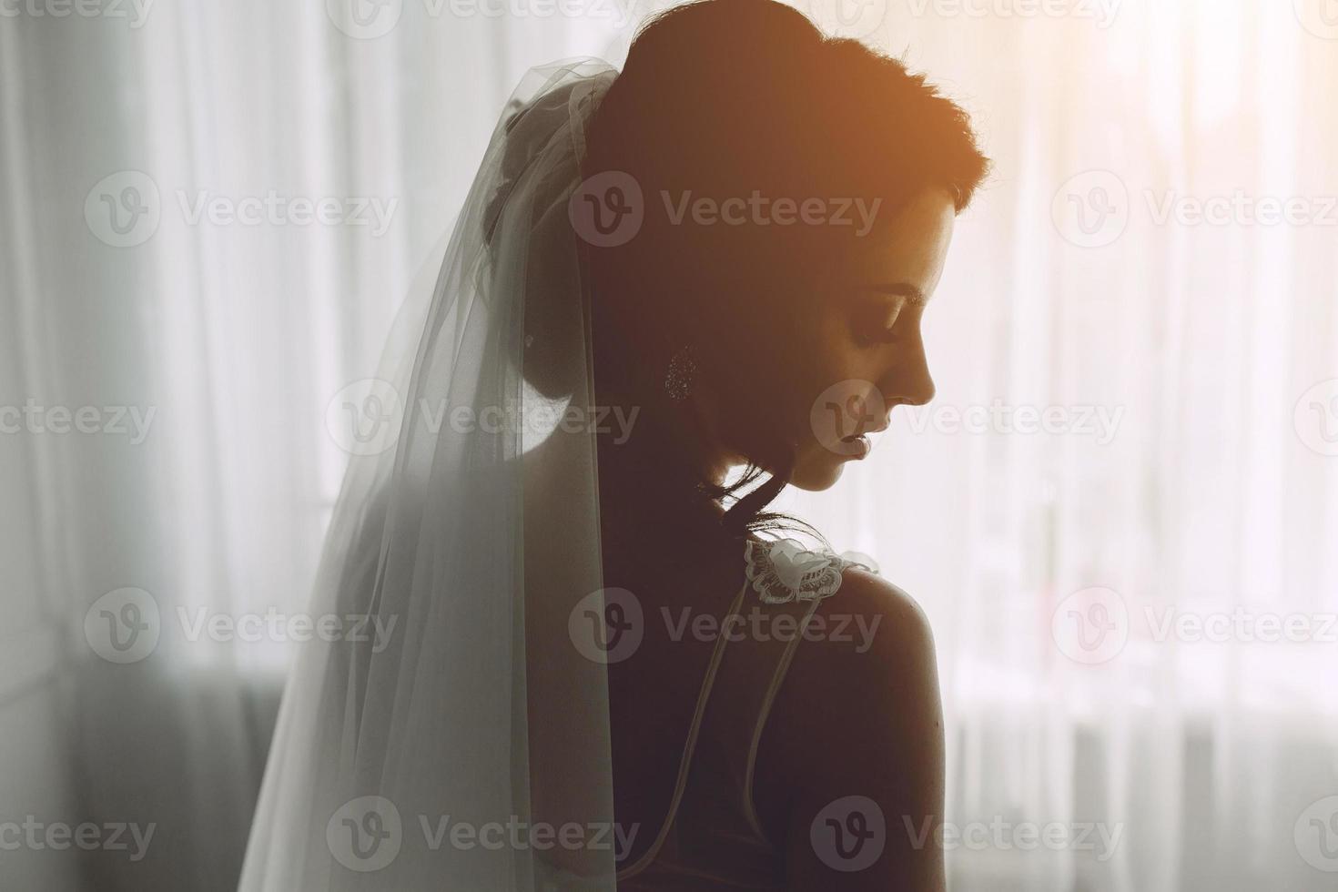mariée posant dans une grande fenêtre photo