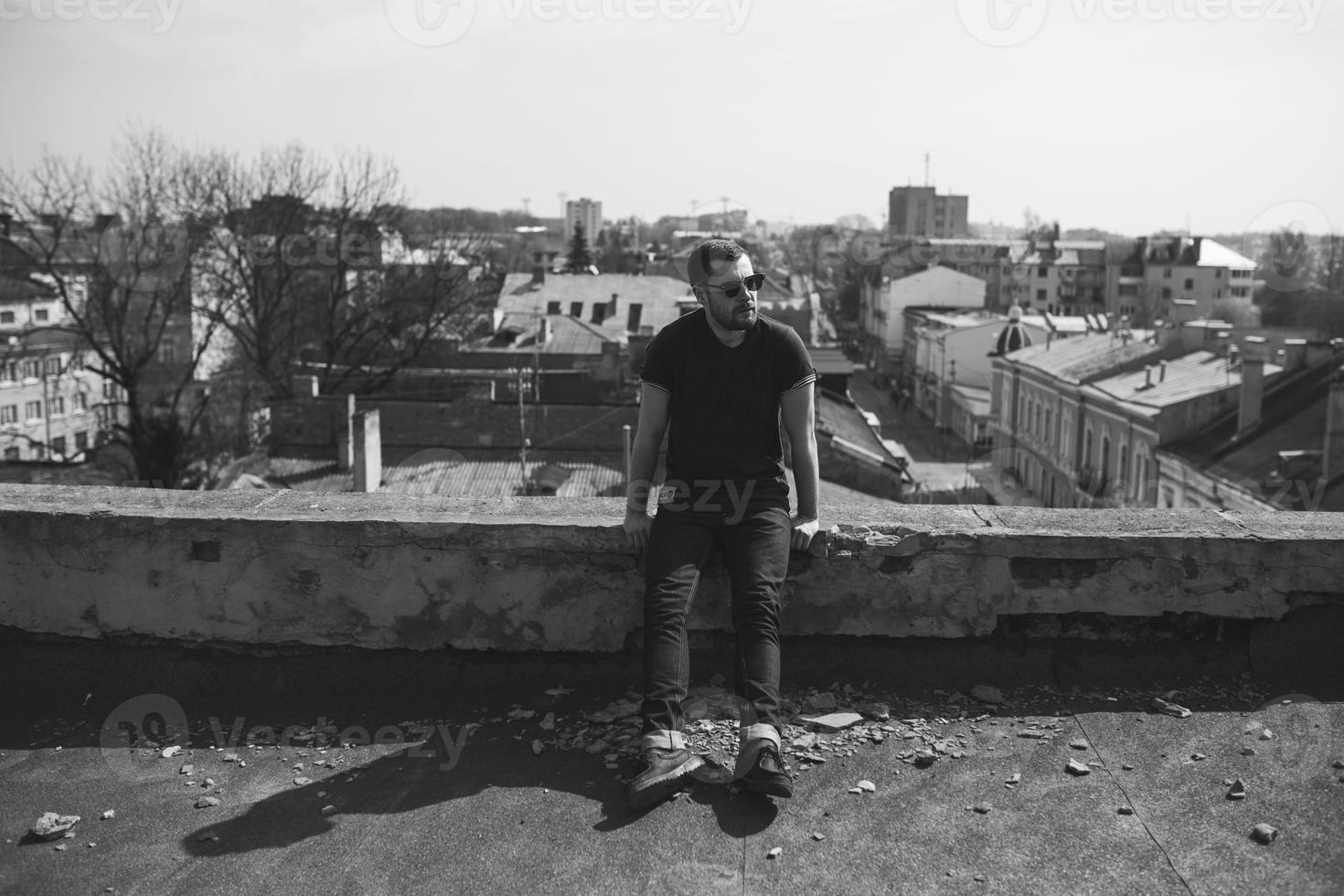 l'homme aux authentiques bottes et jeans lisière sur le toit de l'immeuble de la vieille ville photo