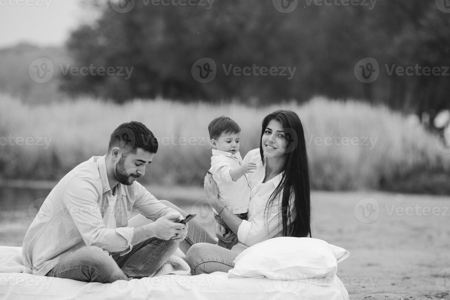 heureuse jeune famille se détendre ensemble sur le lac photo