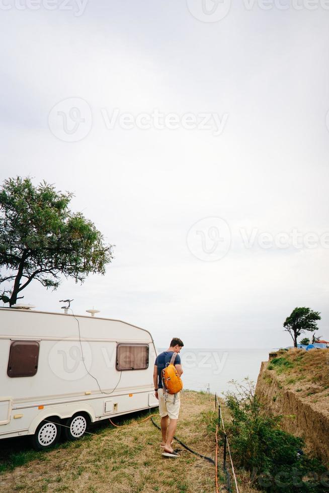 beau, jeune mec posant sur un bord de mer sauvage photo