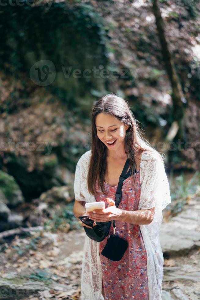 jolie femme avec téléphone marchant dans le parc. photo