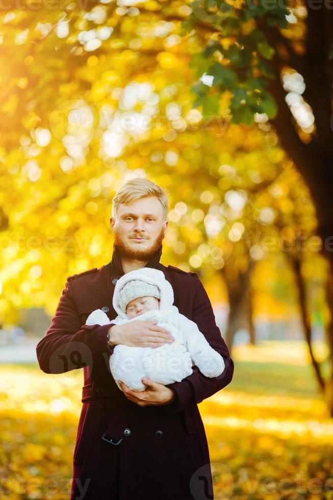 père et fils nouveau-né dans le parc d'automne photo
