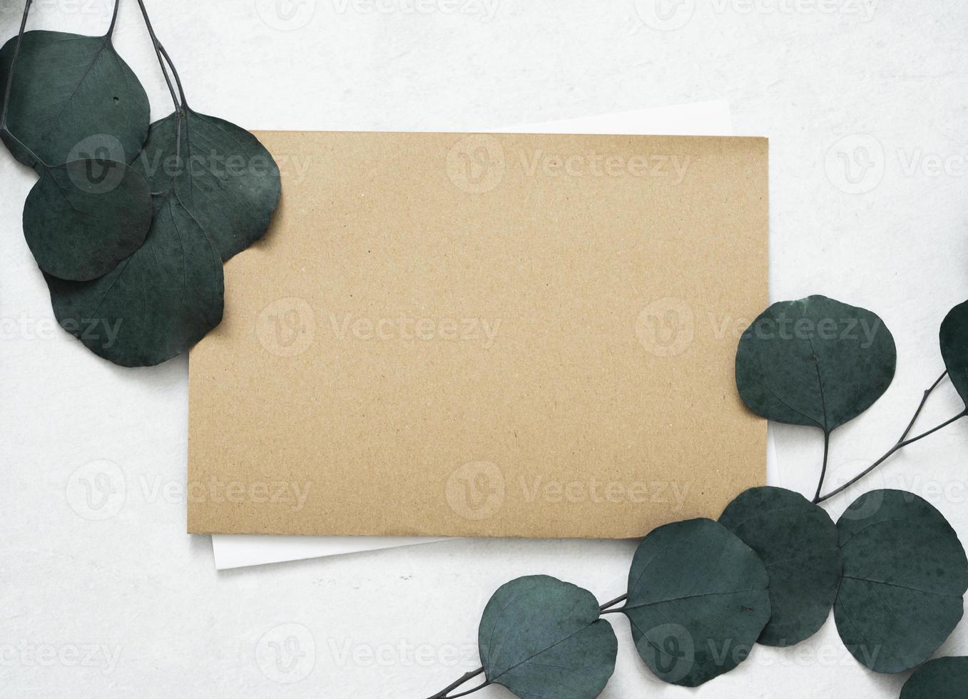 maquette pour une lettre ou une invitation de mariage avec des feuilles de branches d'eucalyptus. photo