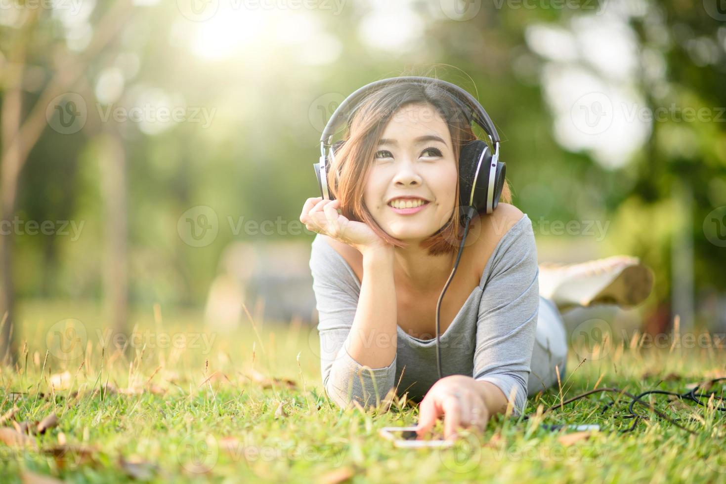 jeune fille écoutant de la musique avec un casque dans le parc de la ville photo