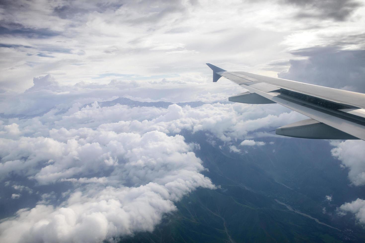 aile d'un avion volant au-dessus des nuages photo