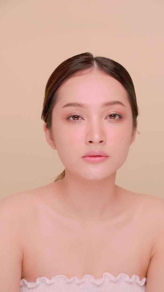 beau visage de jeune femme asiatique à la peau naturelle. portrait de jolie fille avec un maquillage doux et une peau parfaitement belle. photo