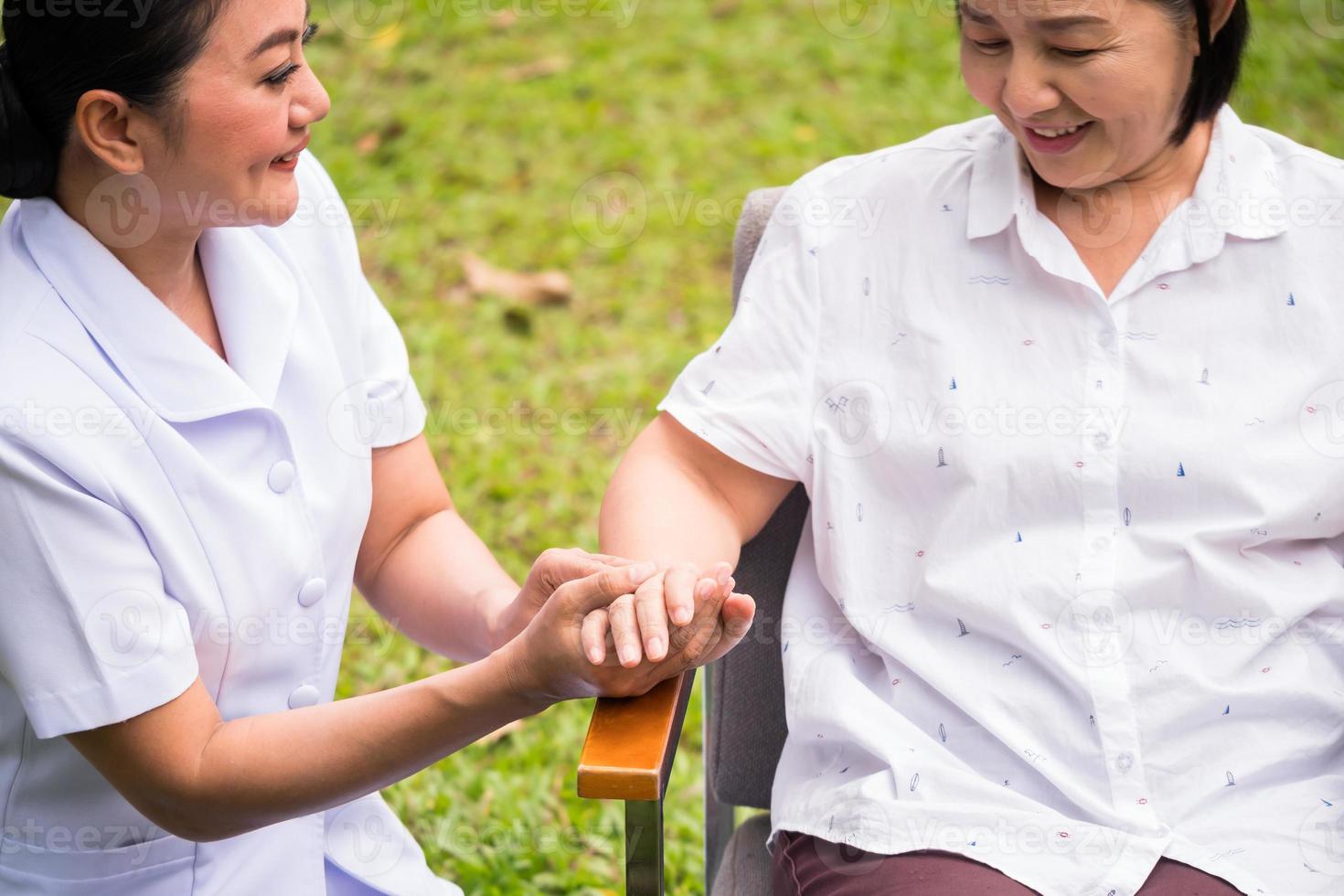 belle infirmière prenant soin d'une patiente au parc de l'hôpital photo