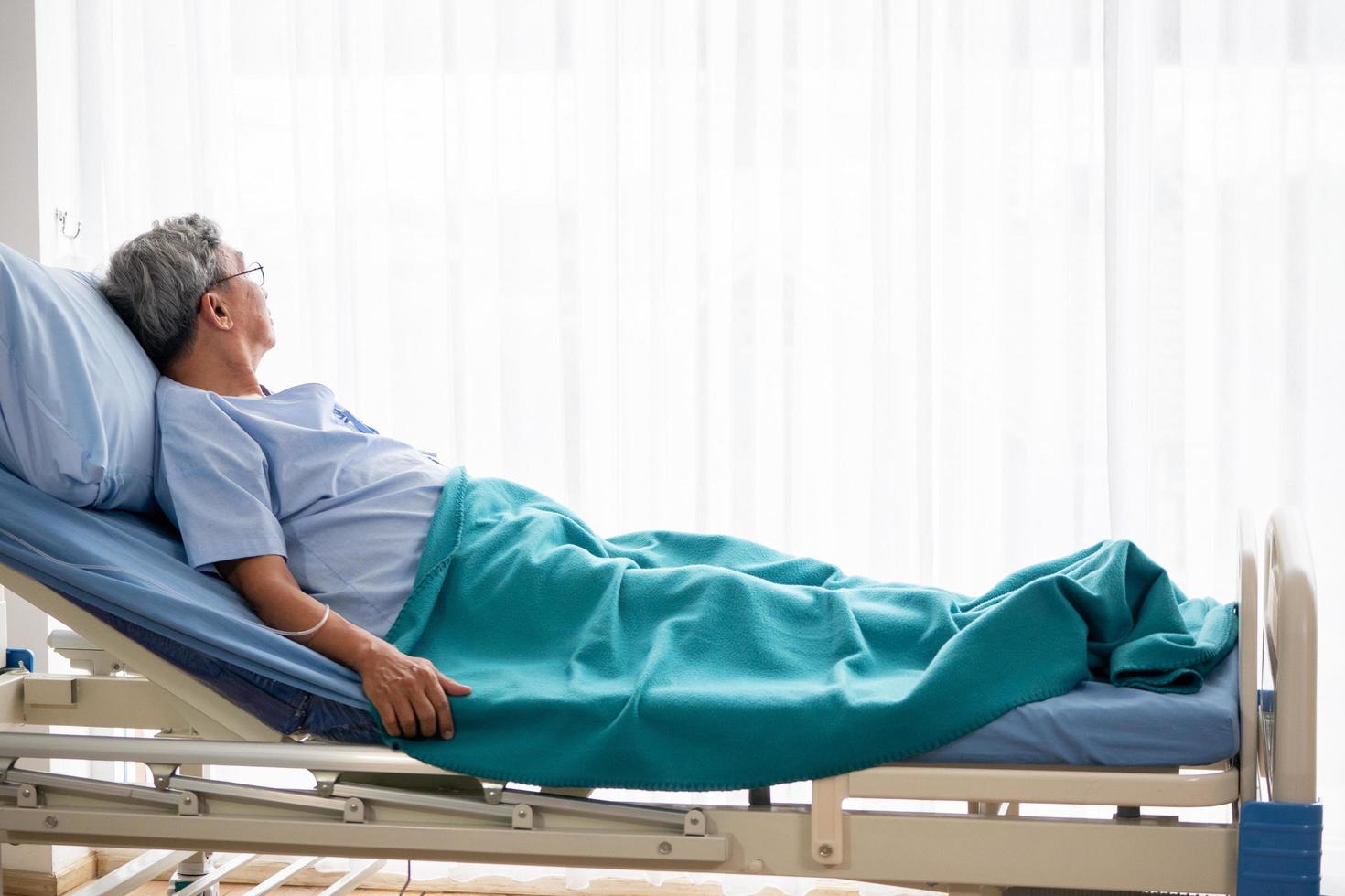 homme patient asiatique allongé sur un lit d'hôpital dans la chambre d'hôpital. photo