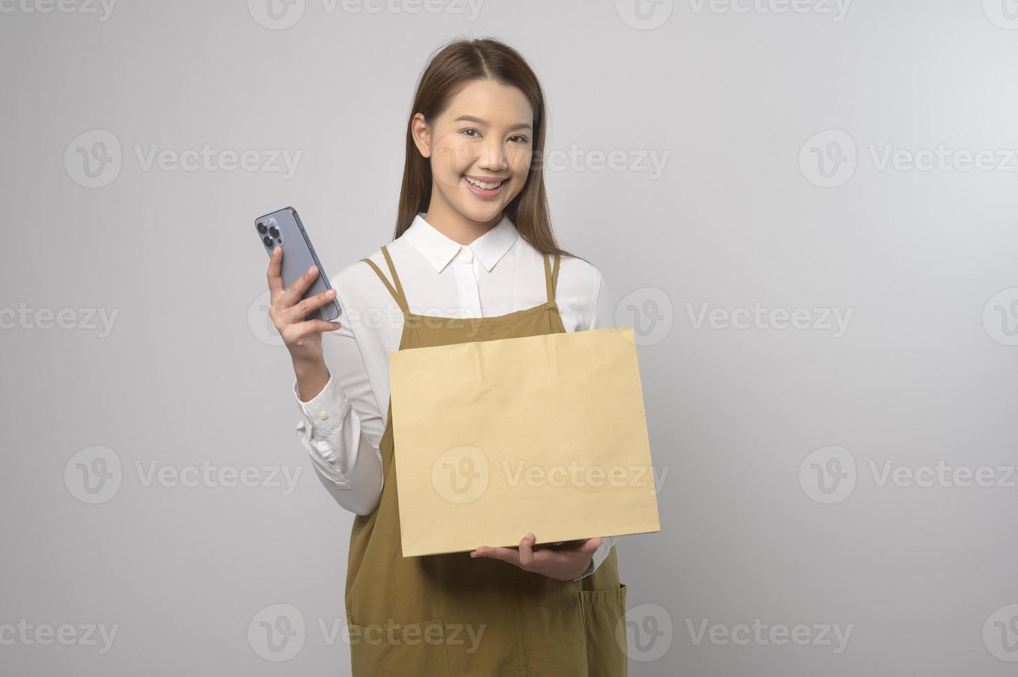 portrait de jeune femme asiatique portant un tablier sur fond blanc studio, cuisine et concept d'entrepreneur photo