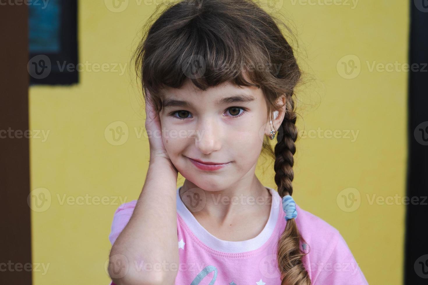 une fille avec un coton-tige thérapeutique chauffant dans l'oreille avec un visage triste et larmoyant tient son oreille. douleur à l'oreille, otite moyenne, gonflement des joues, des gencives, mal de dents, chirurgie pédiatrique, oto-rhino-laryngologie photo