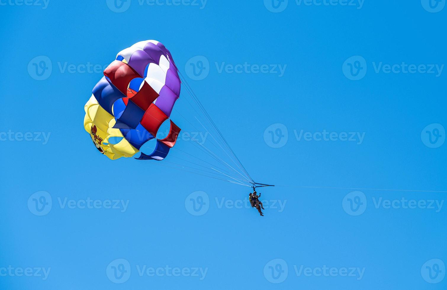 parachute et touristes dans le ciel bleu photo