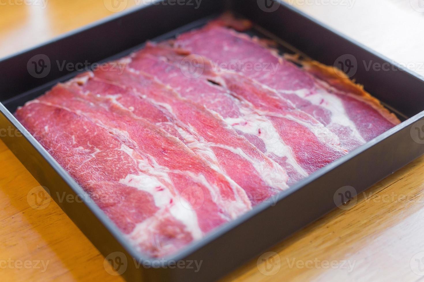 la lame d'huître est du bœuf frais cru tranché a été servi pour le sukiyaki, le bœuf grillé coréen et le restaurant shabu ou yakiniku qu'il a mis sur une assiette noire. photo