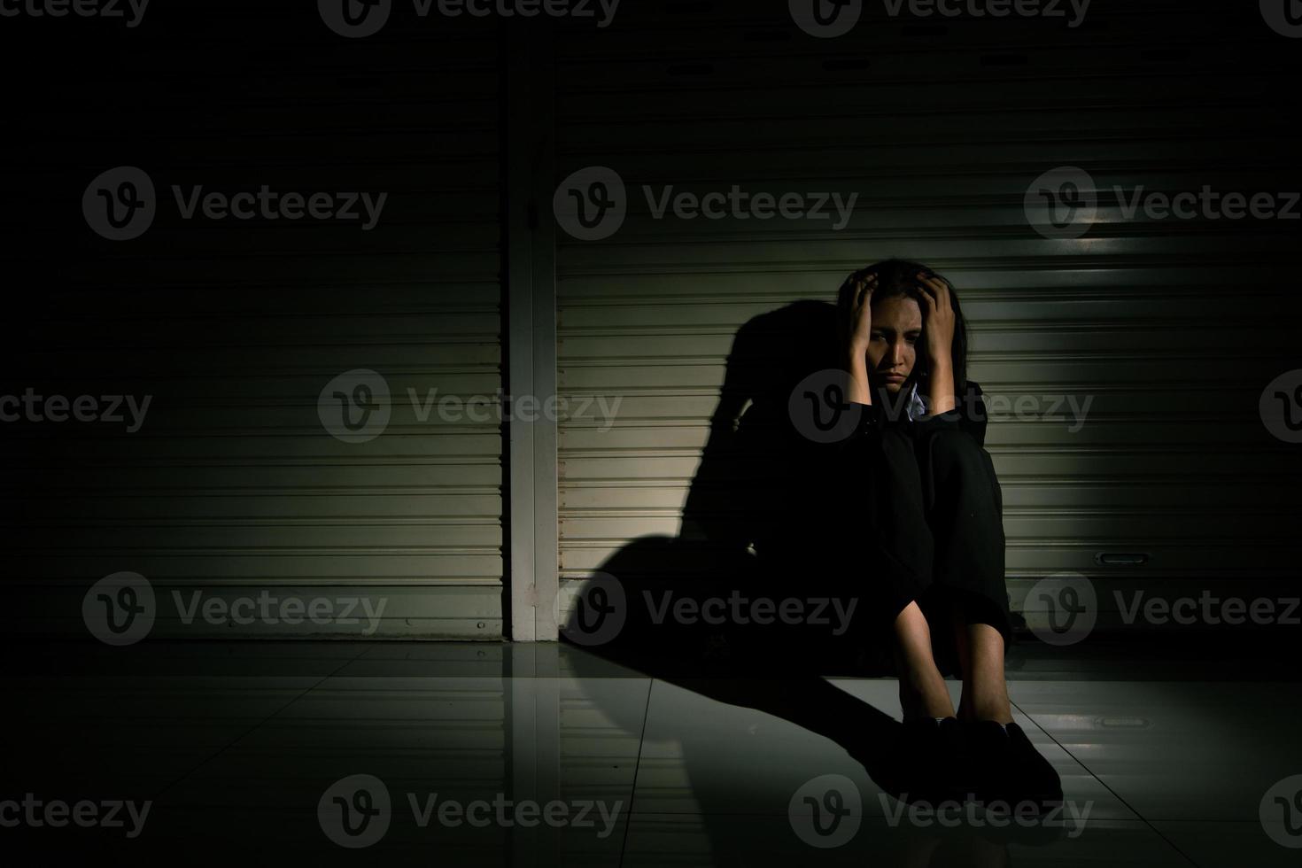 femme déprimée par le problème de désespoir de douleur de stress triste, personne assise dans un magasin fermé dans le couloir seule avec émotion tête en bas désespérée et désespérée. tête dans la main sans issue concept, espace de copie photo
